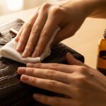 applying leather conditioner to a crocodile handbag